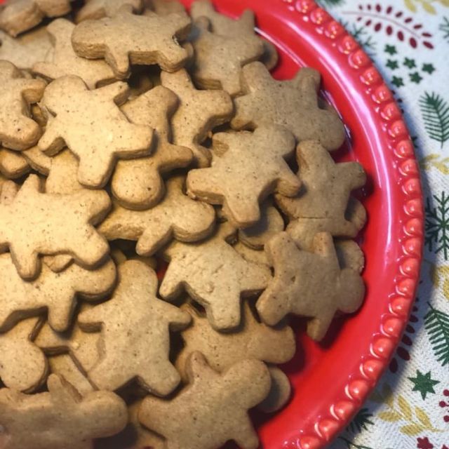 Biscoitos de especiarias em formatos natalinos sobre travessa vermelha